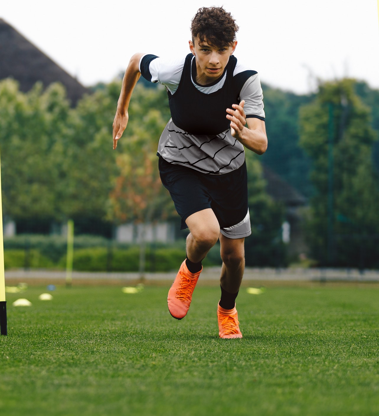 Young football athlete sprinting on a pitch